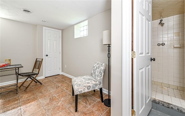 living area featuring baseboards and visible vents
