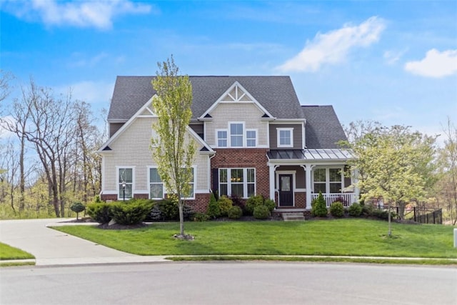 craftsman inspired home featuring a porch, brick siding, a standing seam roof, and a front lawn