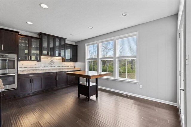 238 Gabriel Dr, Adams Twp, PA 16046 - kitchen featuring double oven, decorative backsplash, glass insert cabinets, baseboards, and dark brown cabinetry