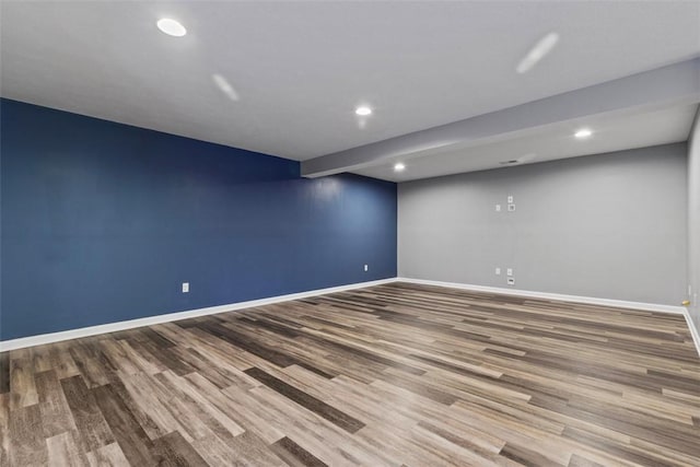 finished below grade area featuring baseboards, recessed lighting, and wood finished floors