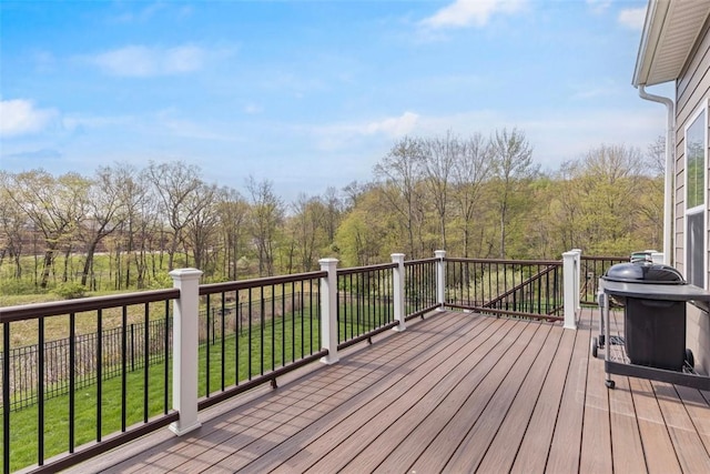 wooden terrace with a lawn, grilling area, and a forest view