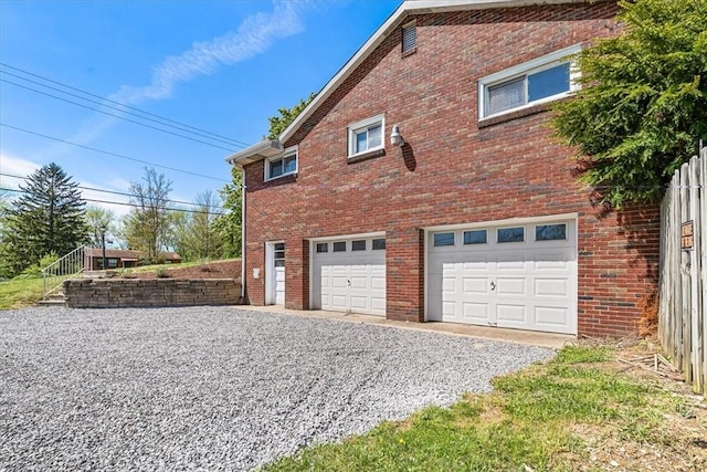 2410 Nicholson Rd, Franklin Park, PA 15143 - view of side of home featuring gravel driveway, brick siding, and an attached garage