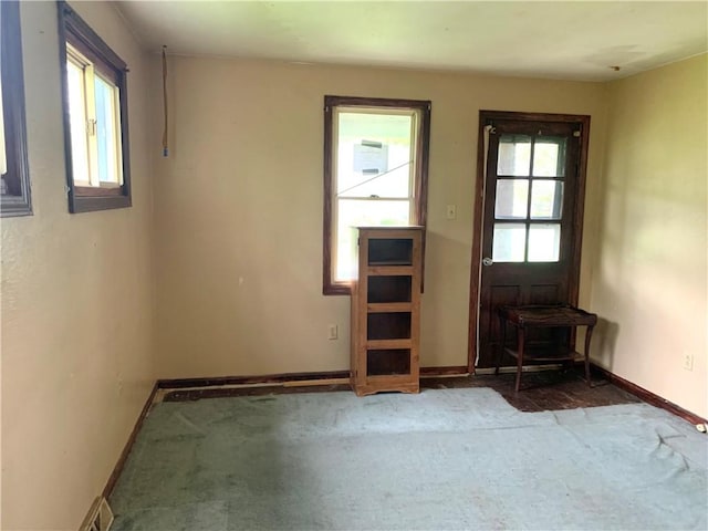 unfurnished room with baseboards and carpet flooring