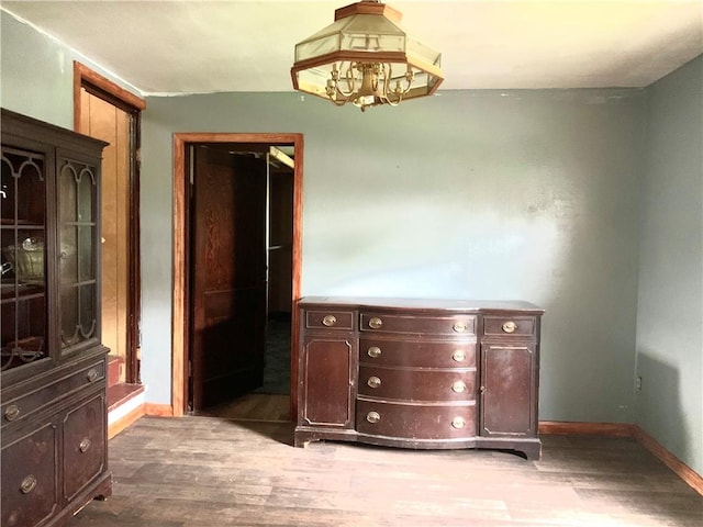 unfurnished dining area with baseboards and wood finished floors