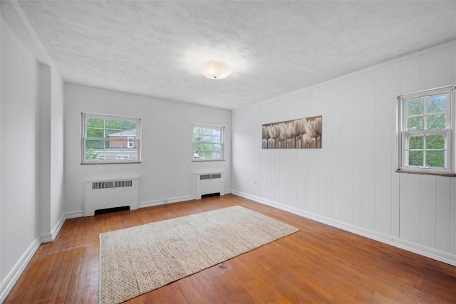 4044 Cloverlea St, Brentwood, PA 15227 - spare room featuring baseboards, radiator, and hardwood / wood-style flooring