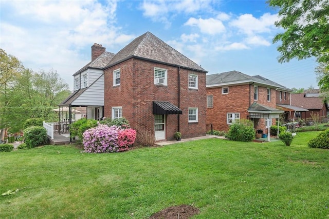 4044 Cloverlea St, Brentwood, PA 15227 - rear view of property featuring brick siding, a lawn, and a chimney