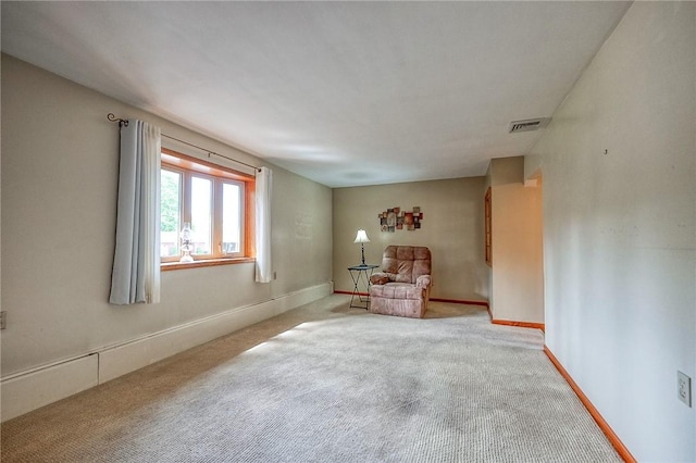 sitting room with baseboards, visible vents, and carpet