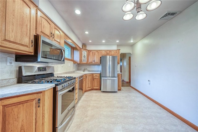 kitchen featuring visible vents, baseboards, light countertops, a sink, and appliances with stainless steel finishes
