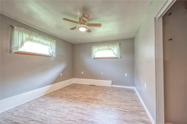 spare room featuring baseboards, a ceiling fan, and wood finished floors