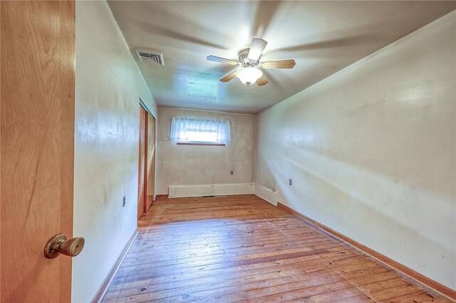unfurnished room featuring baseboards, a ceiling fan, hardwood / wood-style floors, and visible vents
