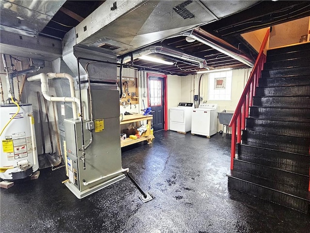 basement with a sink, gas water heater, stairs, heating unit, and washing machine and dryer
