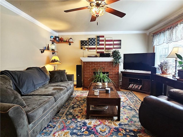 living room with a brick fireplace, a ceiling fan, ornamental molding, and wood finished floors