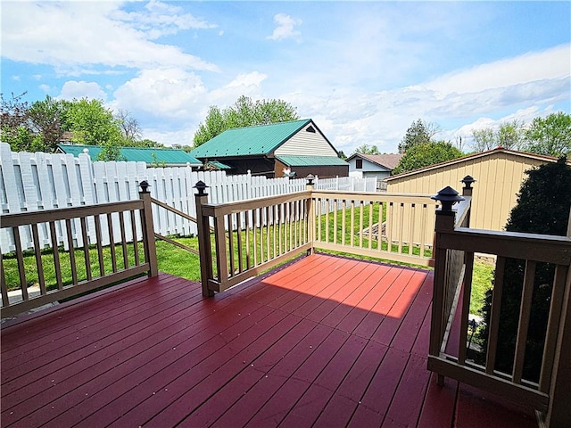 wooden deck with a fenced backyard and a lawn
