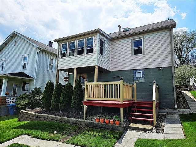 rear view of property featuring a yard and a deck