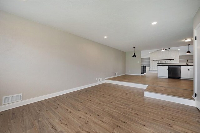 4917 Leona Dr, Baldwin Boro, PA 15227 - unfurnished living room featuring a ceiling fan, visible vents, wood finished floors, a sink, and baseboards
