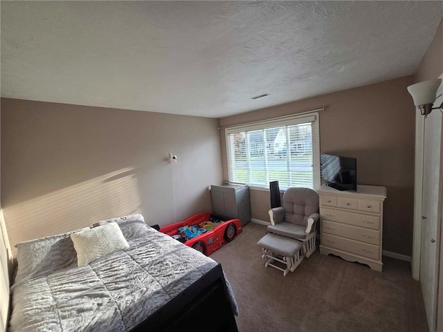 carpeted bedroom with baseboards and a textured ceiling