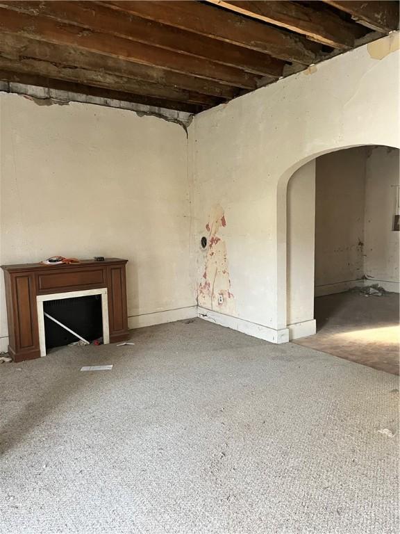 unfurnished living room with arched walkways