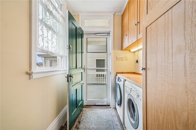 laundry room featuring baseboards, washer and clothes dryer, and cabinet space