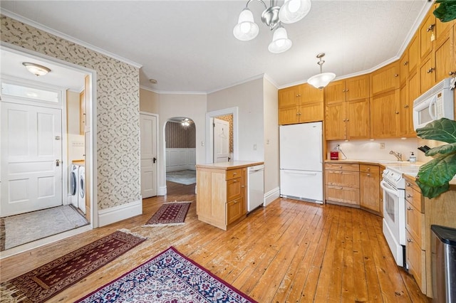 kitchen with white appliances, light wood-type flooring, washer and clothes dryer, light countertops, and arched walkways