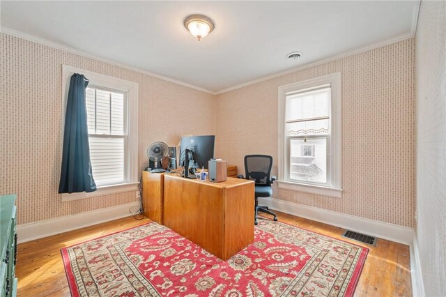 office area featuring visible vents, wood finished floors, baseboards, ornamental molding, and wallpapered walls