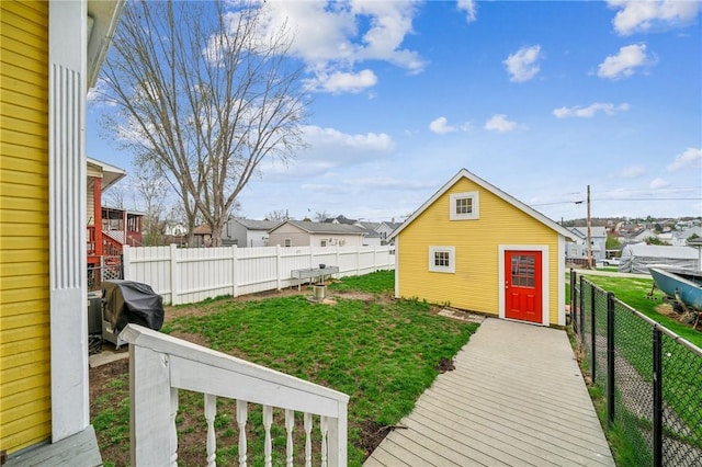view of yard featuring a fenced backyard, an outbuilding, and a residential view