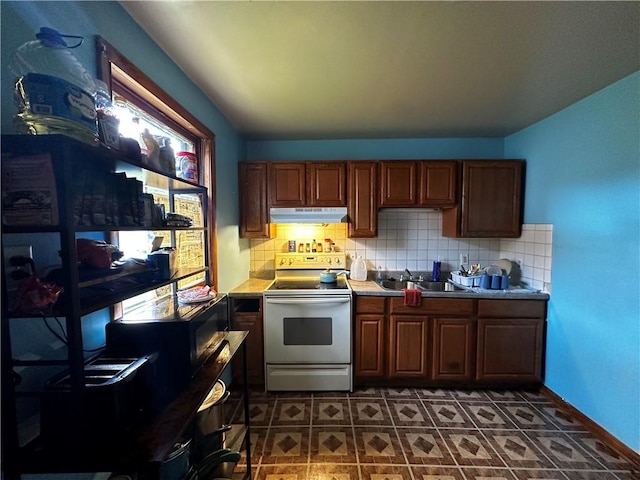 606 Chestnut St, New Castle/3Rd, PA 16101 - kitchen featuring electric range, under cabinet range hood, decorative backsplash, a sink, and dark tile patterned floors