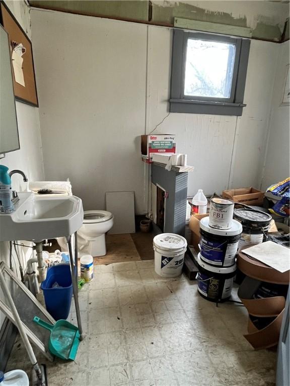bathroom featuring toilet, tile patterned floors, and a sink