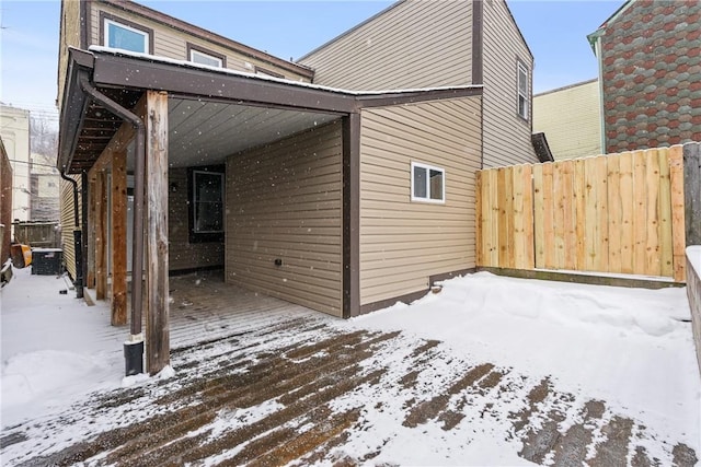 snow covered property with fence
