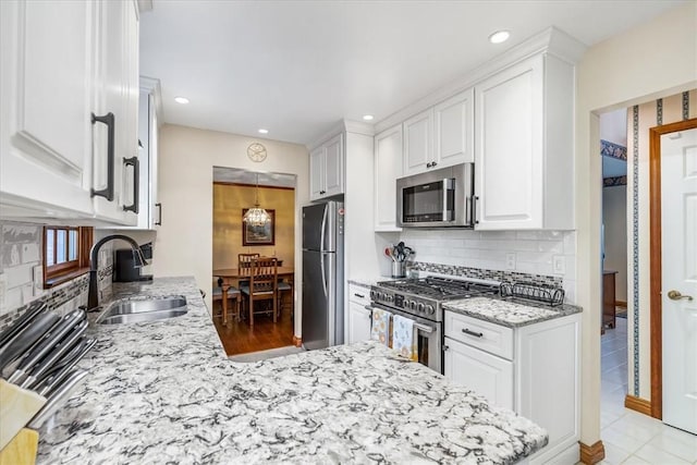 4012 Forest Dr, Hopewell Twp Bea, PA 15001 - kitchen with light stone countertops, a sink, stainless steel appliances, white cabinetry, and decorative backsplash