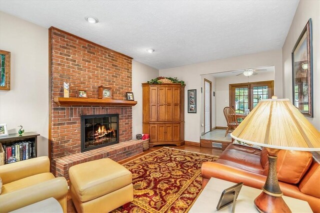 4012 Forest Dr, Hopewell Twp Bea, PA 15001 - living area featuring ceiling fan, a textured ceiling, a brick fireplace, wood finished floors, and baseboards
