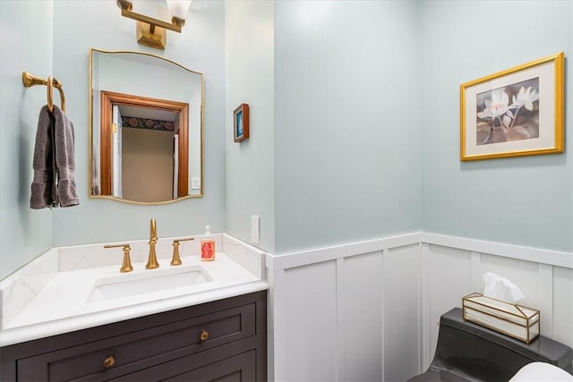 4012 Forest Dr, Hopewell Twp Bea, PA 15001 - half bathroom featuring a decorative wall, toilet, vanity, and a wainscoted wall