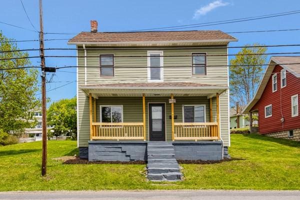 view of front of home with a porch and a front lawn
