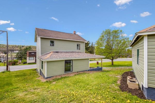 rear view of property featuring a lawn