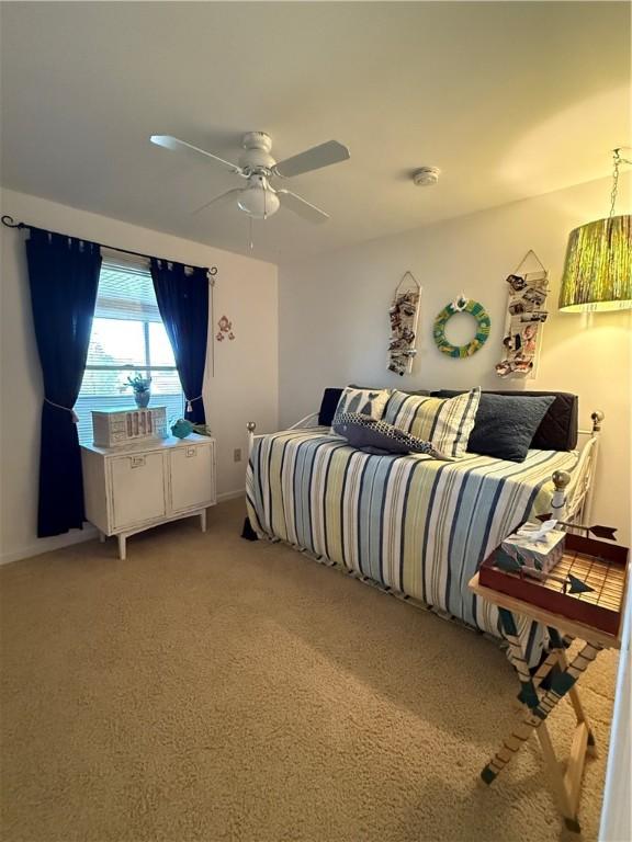 bedroom featuring baseboards, ceiling fan, and light colored carpet