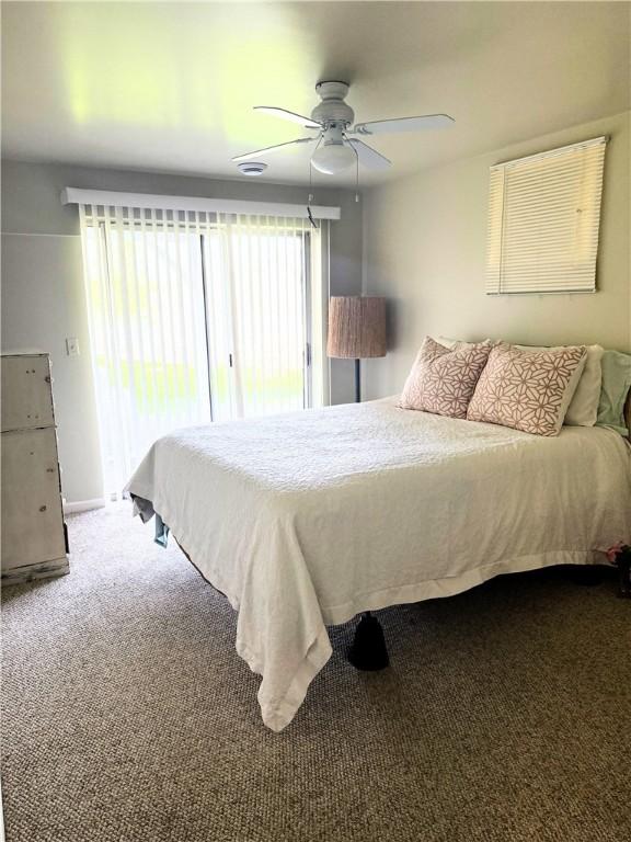 bedroom with a ceiling fan, access to outside, carpet, and multiple windows