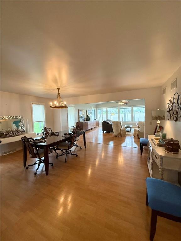 dining space with visible vents, a notable chandelier, wood finished floors, and a wealth of natural light