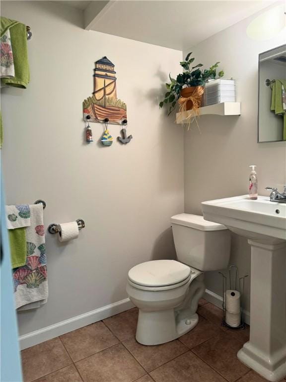 bathroom featuring toilet, tile patterned floors, and baseboards