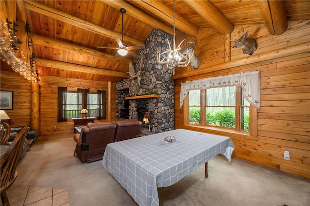 carpeted living room featuring a healthy amount of sunlight, wood ceiling, vaulted ceiling with beams, and wooden walls