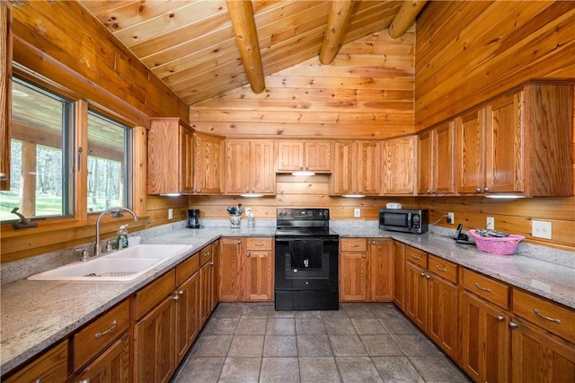 kitchen featuring wood walls, lofted ceiling with beams, stainless steel microwave, a sink, and black / electric stove