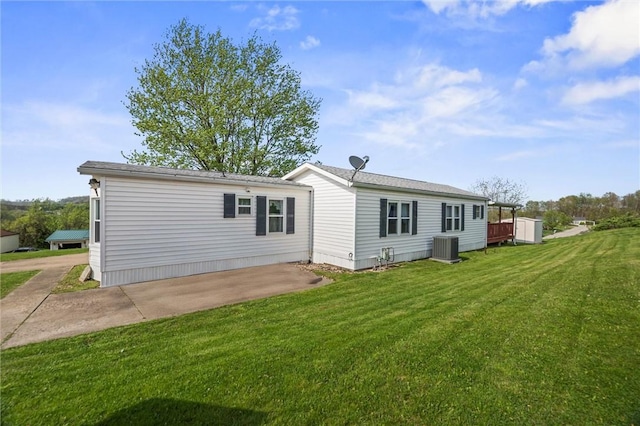 rear view of house featuring a yard, a patio, and central AC