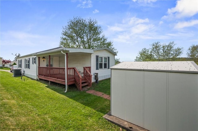 back of house with a yard, cooling unit, and an outdoor structure