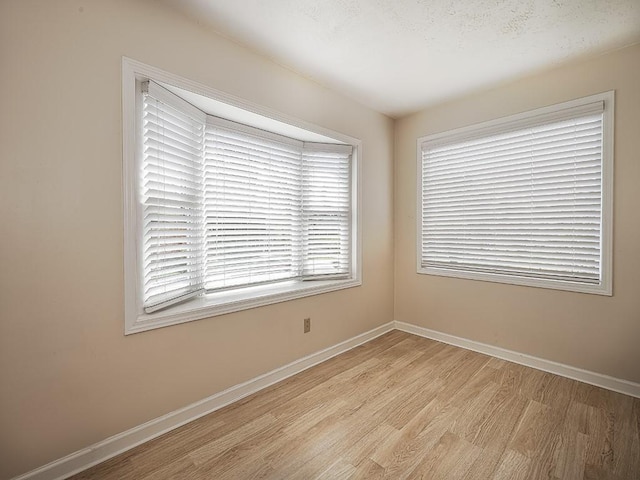 empty room with light wood-style floors and baseboards