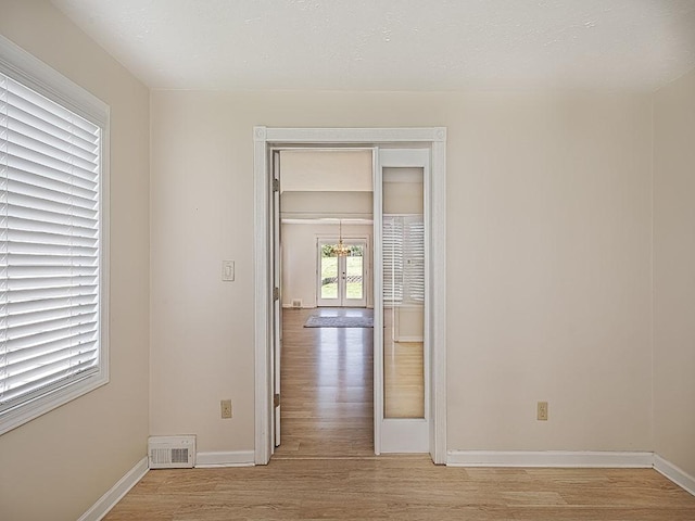 unfurnished room with baseboards, visible vents, and light wood-style flooring