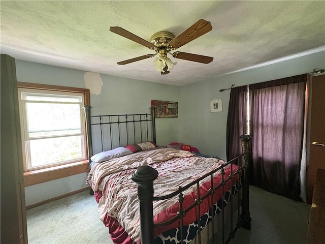 bedroom with baseboards, ceiling fan, carpet, and a textured ceiling