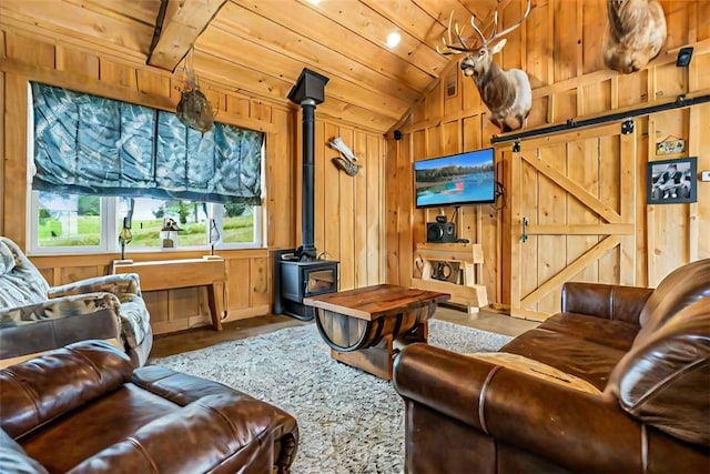 6181 Brown Rd, Penn Twp, PA 16002 - living area featuring vaulted ceiling, a wood stove, a barn door, wood walls, and wooden ceiling