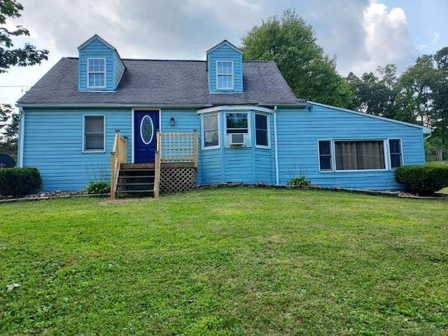 view of front of house featuring roof with shingles, cooling unit, a deck, and a front yard