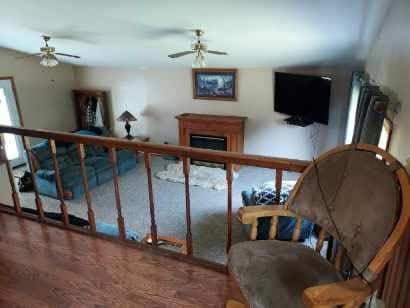 sitting room featuring a ceiling fan and a fireplace