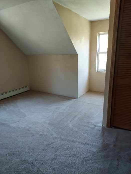 bonus room with a baseboard radiator, carpet, and vaulted ceiling