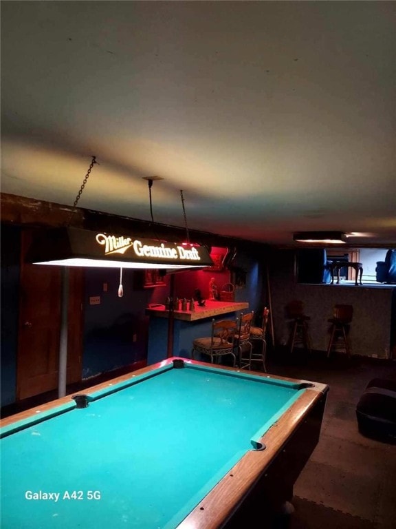 game room with a bar, billiards, and wood finished floors