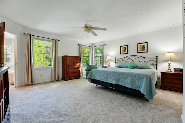 bedroom with ornamental molding, a ceiling fan, and light colored carpet